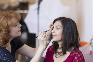 Creative professional tips - Makeup artist applying makeup to a woman's face
