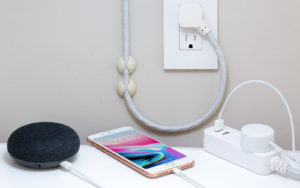 Phone, bluetooth speaker, and other devices neatly plugged into outlets.