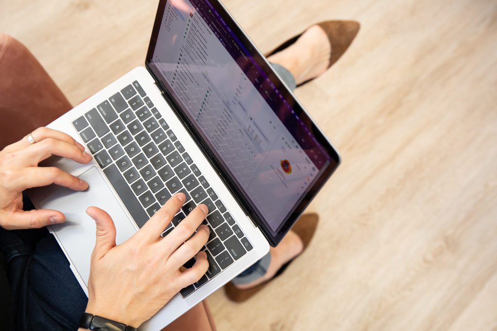 web designer typing on keyboard, with animal print shoes in the background
